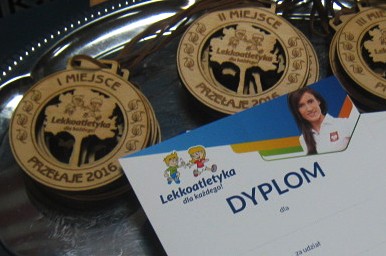 zdjęcie przedstawia dyplom i medale z zawodów